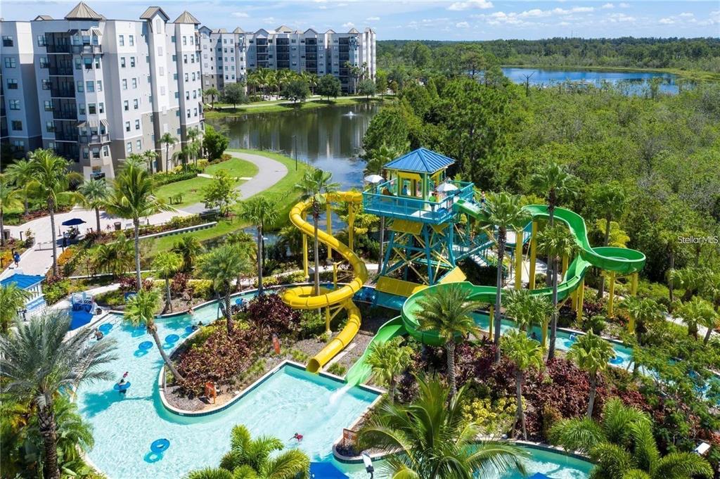 An aerial view shows a resort-style swimming pool with water slides and a multi-story building — 14501 GROVE RESORT AVENUE UNIT 3222, WINTER GARDEN, FL