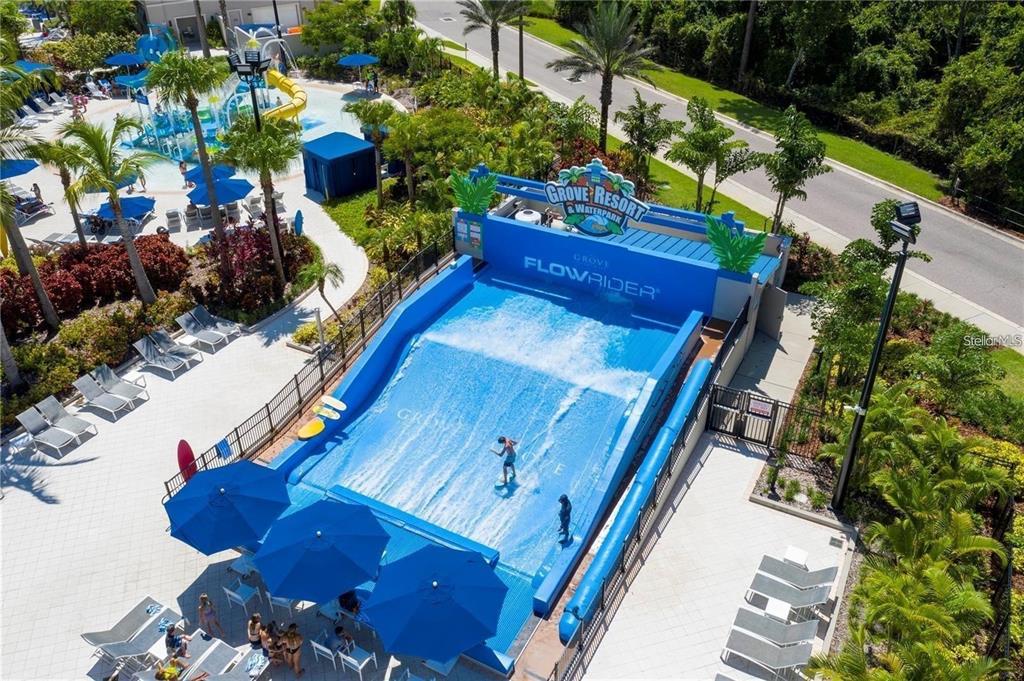 An aerial view shows a FlowRider surf simulator at a resort waterpark with lounge chairs — 14501 GROVE RESORT AVENUE UNIT 3222, WINTER GARDEN, FL