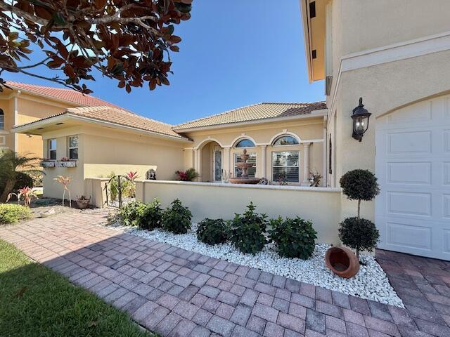 A paved walkway leads to the entrance of a house with a stone fountain — 5665 61st Place, Vero Beach FL 32967, VERO BEACH, FL