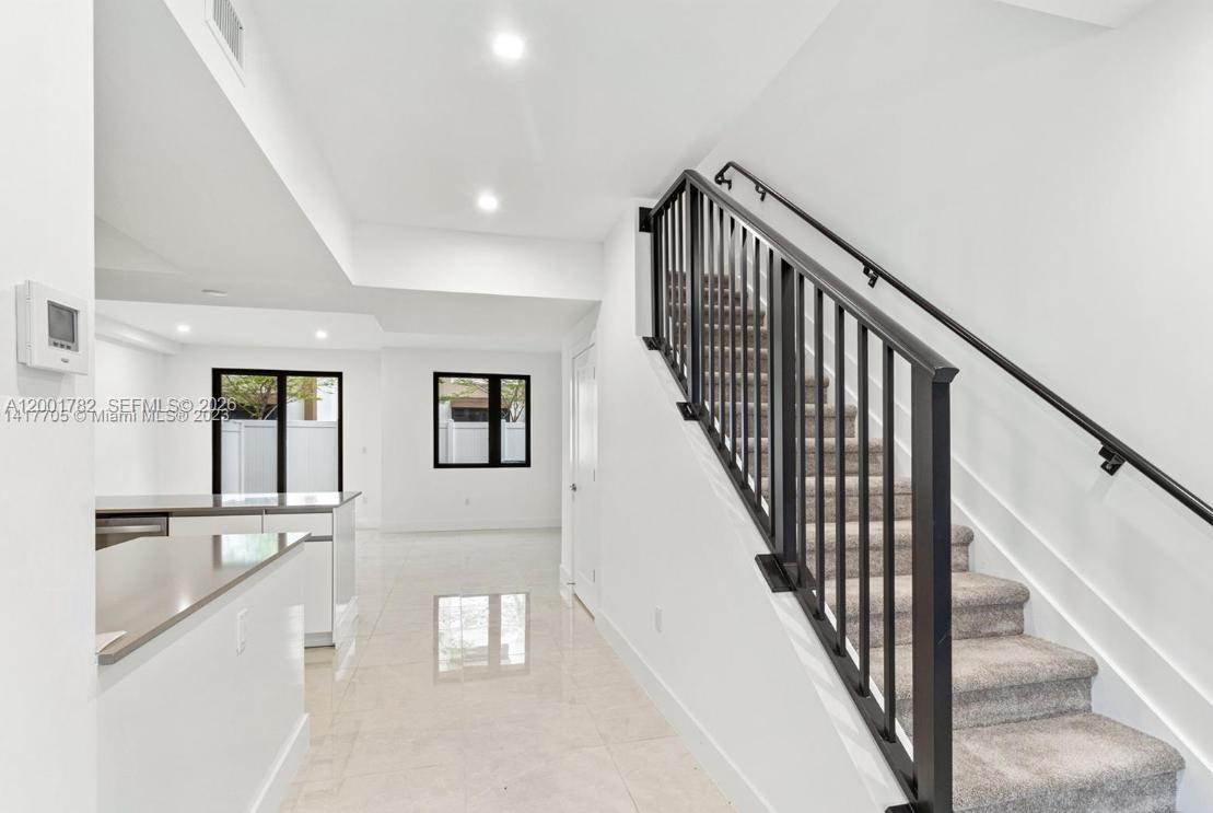 A modern kitchen features white cabinets, stainless steel appliances, and a large peninsula countertop — 4130 N Oak Pl # 4130, Dania Beach FL 33314, DANIA BEACH, FL