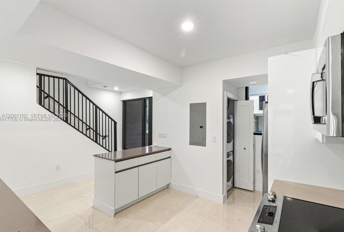 A modern kitchen features white cabinets, stainless steel appliances, and light tile flooring — 4130 N Oak Pl # 4130, Dania Beach FL 33314, DANIA BEACH, FL