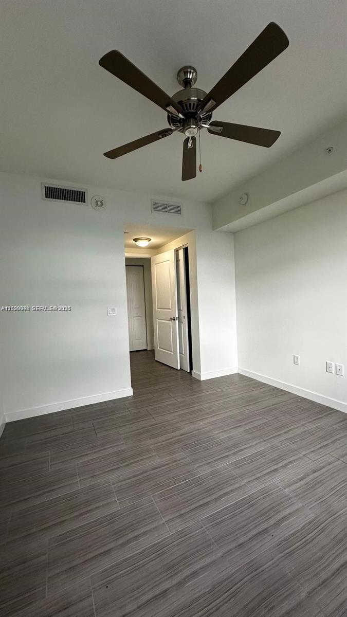 A room with a ceiling fan, white walls, and gray tile flooring — 1776 Polk St # 1403, Hollywood FL 33020, HOLLYWOOD, FL