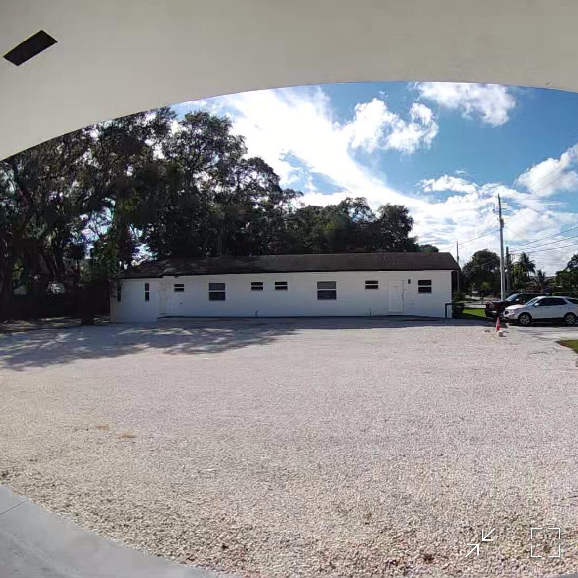 A long, white, single-story building sits behind a large, open gravel parking lot — 1702 NE 146th Street, Miami FL 33181, MIAMI, FL