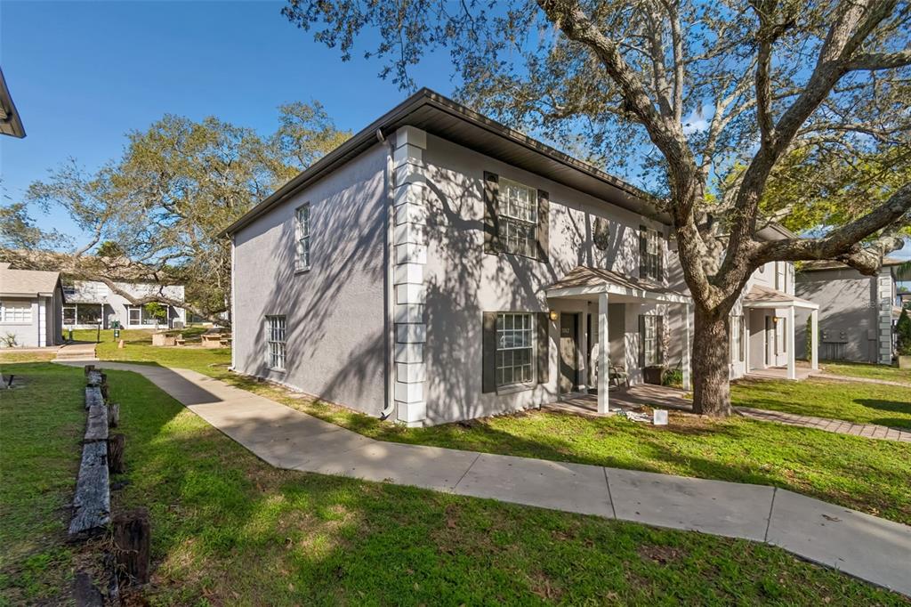 A two-story gray apartment building with white corner accents and a concrete walkway — 5182 SUNRIDGE PALMS DRIVE UNIT 5182, TAMPA, FL