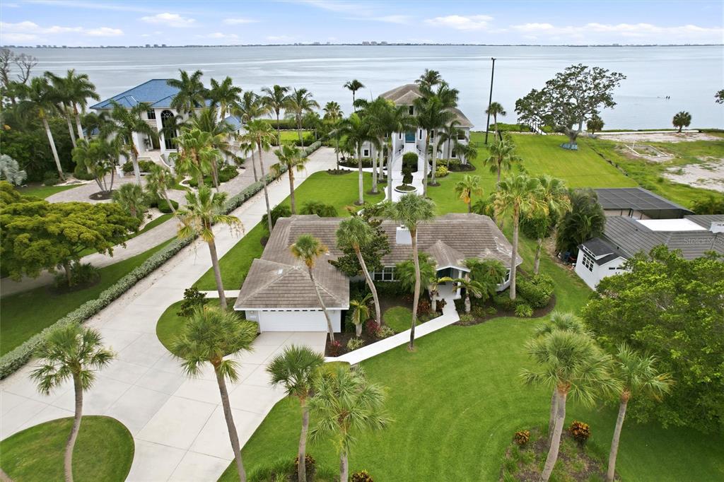 An aerial view shows a single-story house with a tiled roof and surrounding palm trees — 7524 WESTMORELAND DRIVE, SARASOTA, FL