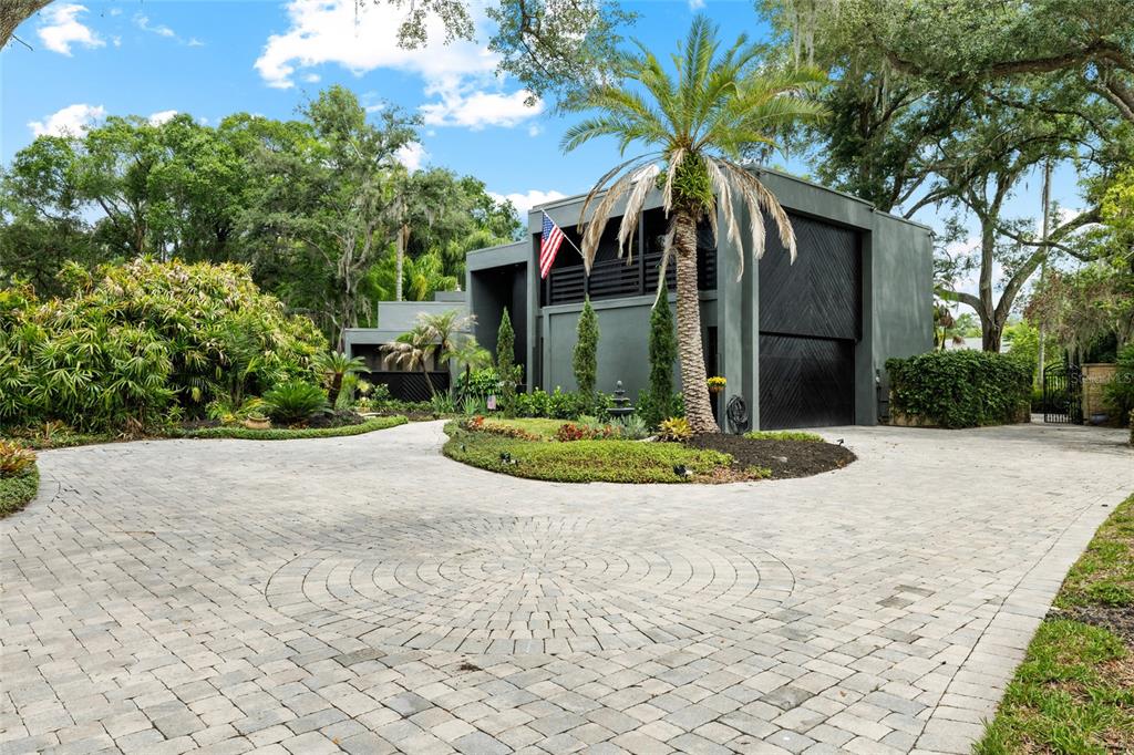 A modern gray two-story house features a circular paver driveway and a prominent palm tree — 410 MONTROSE AVENUE, TEMPLE TERRACE, FL