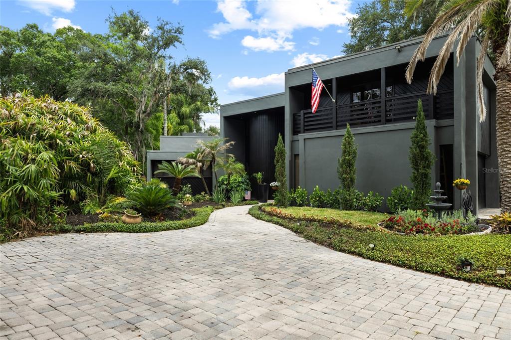 A modern two-story house with dark gray exterior walls and a paved stone driveway — 410 MONTROSE AVENUE, TEMPLE TERRACE, FL
