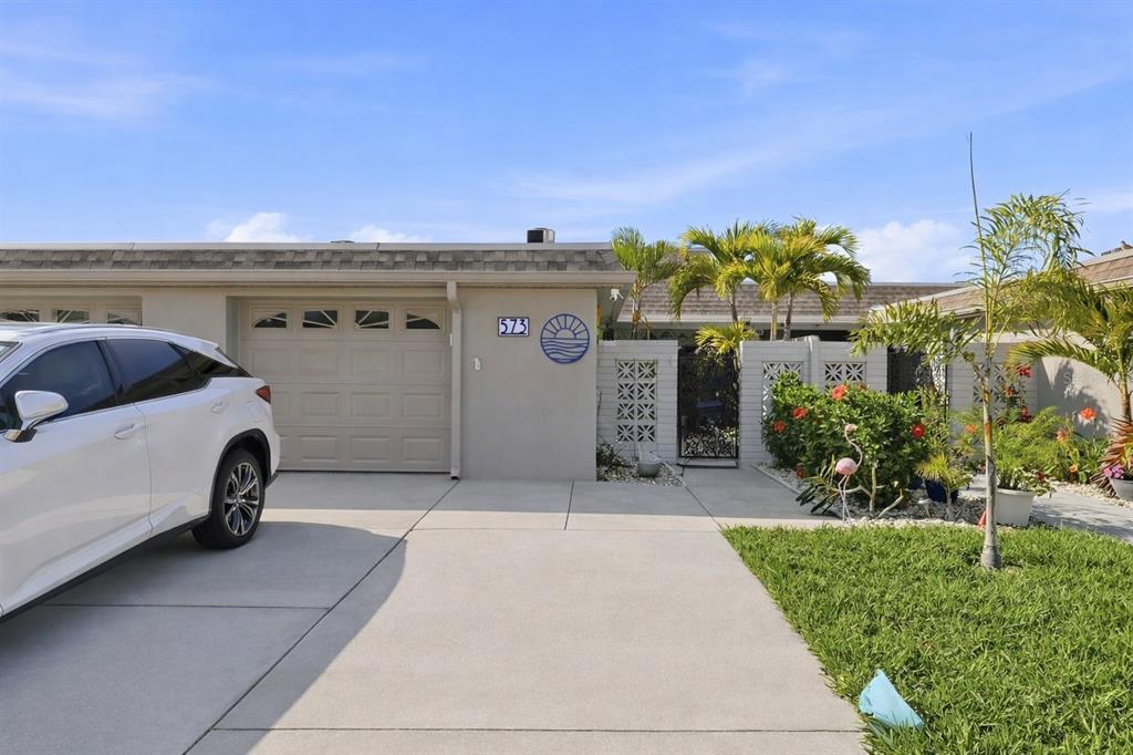 A white car is parked in the driveway of a single-story home with a garage — 573 BOCA CIEGA POINT BOULEVARD N, ST PETERSBURG, FL