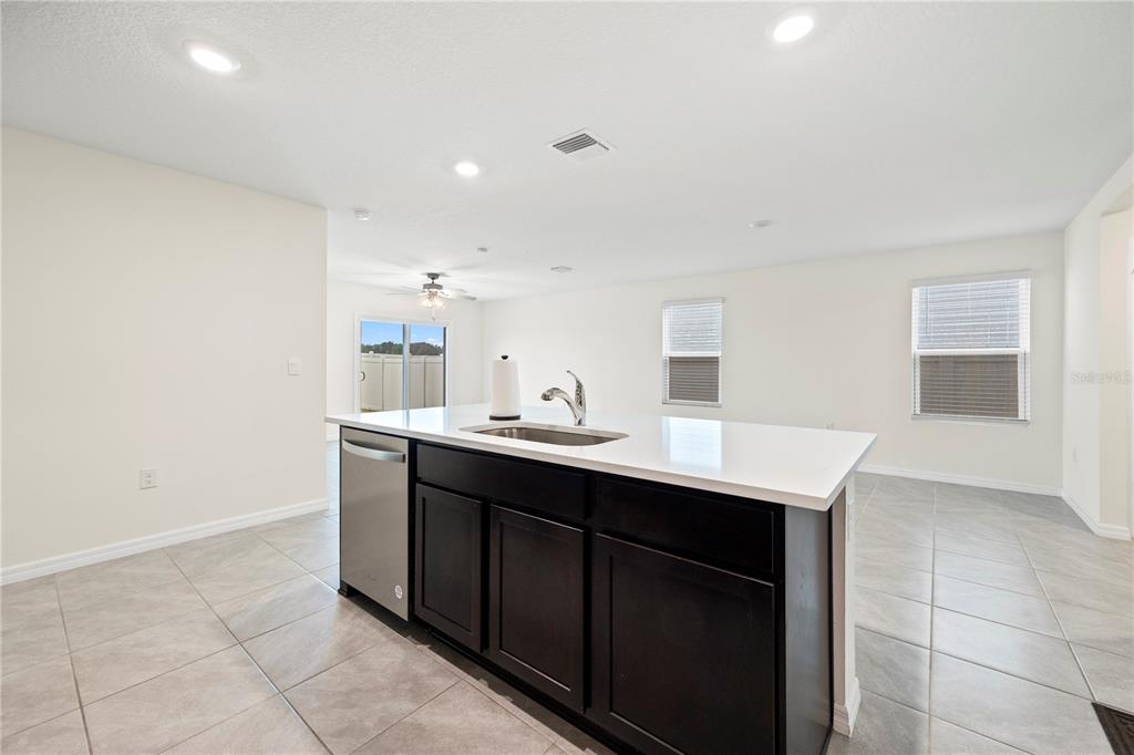 A kitchen island with a stainless steel sink and dishwasher sits on a tiled floor — 24595 NW 11TH PLACE, NEWBERRY, FL