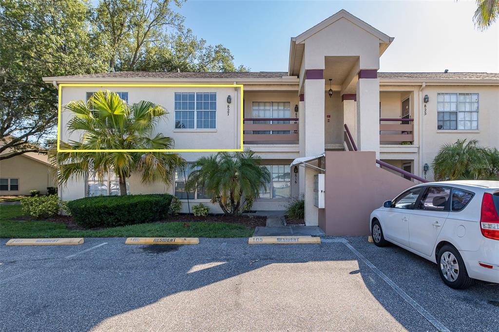 A two-story apartment building exterior features a highlighted upper-level unit with a palm tree — 7900 HARDWICK DRIVE UNIT 827, NEW PORT RICHEY, FL