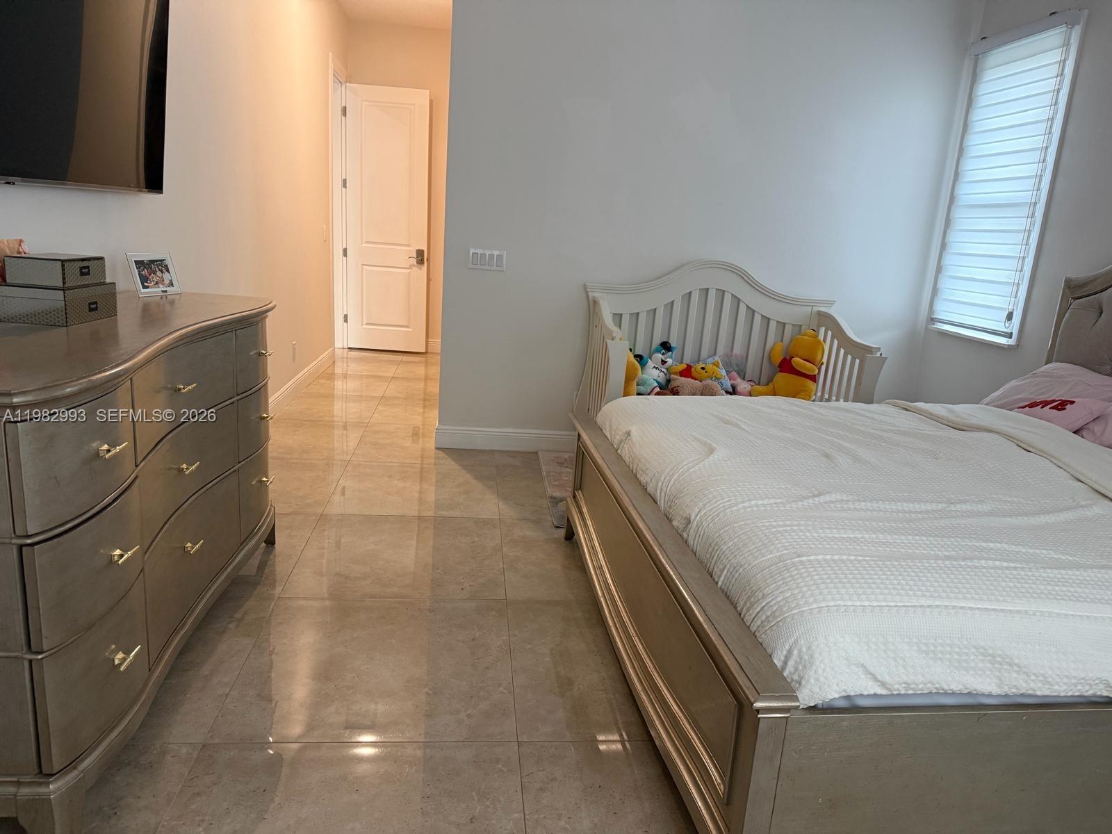 A bedroom features a metallic dresser, a bed with a toddler rail, and tiled flooring — 3646 28TH AVE SE, Naples FL 34117, NAPLES, FL