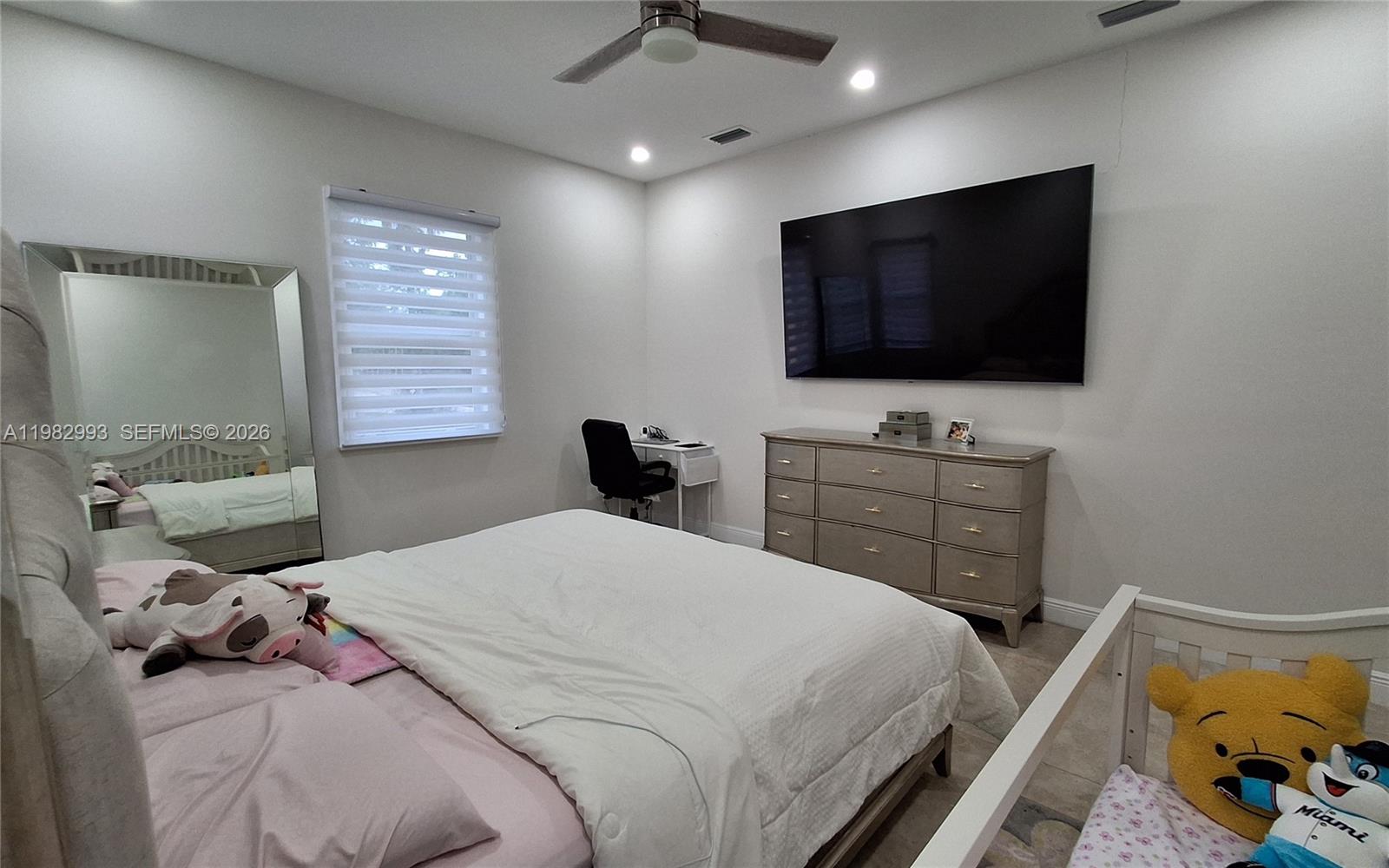 A bedroom features a bed, a dresser with a wall-mounted television, and a crib — 3646 28TH AVE SE, Naples FL 34117, NAPLES, FL