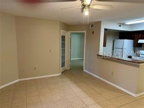 A tiled dining area features a ceiling fan and an open view into the kitchen — 401 FOUNTAINHEAD CIRCLE UNIT 155, KISSIMMEE, FL