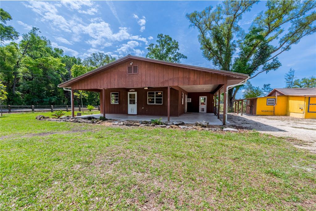 A brown wooden house with a covered porch sits on a grassy lot — 6150 NW COUNTY ROAD 345, CHIEFLAND, FL