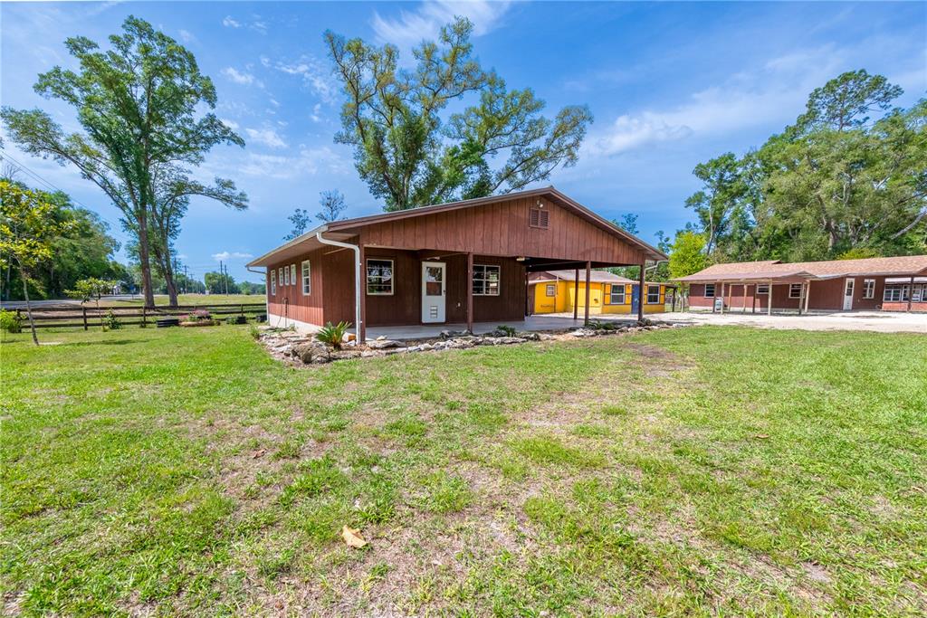 A brown wood-sided house with a covered porch sits on a grassy lot — 6150 NW COUNTY ROAD 345, CHIEFLAND, FL