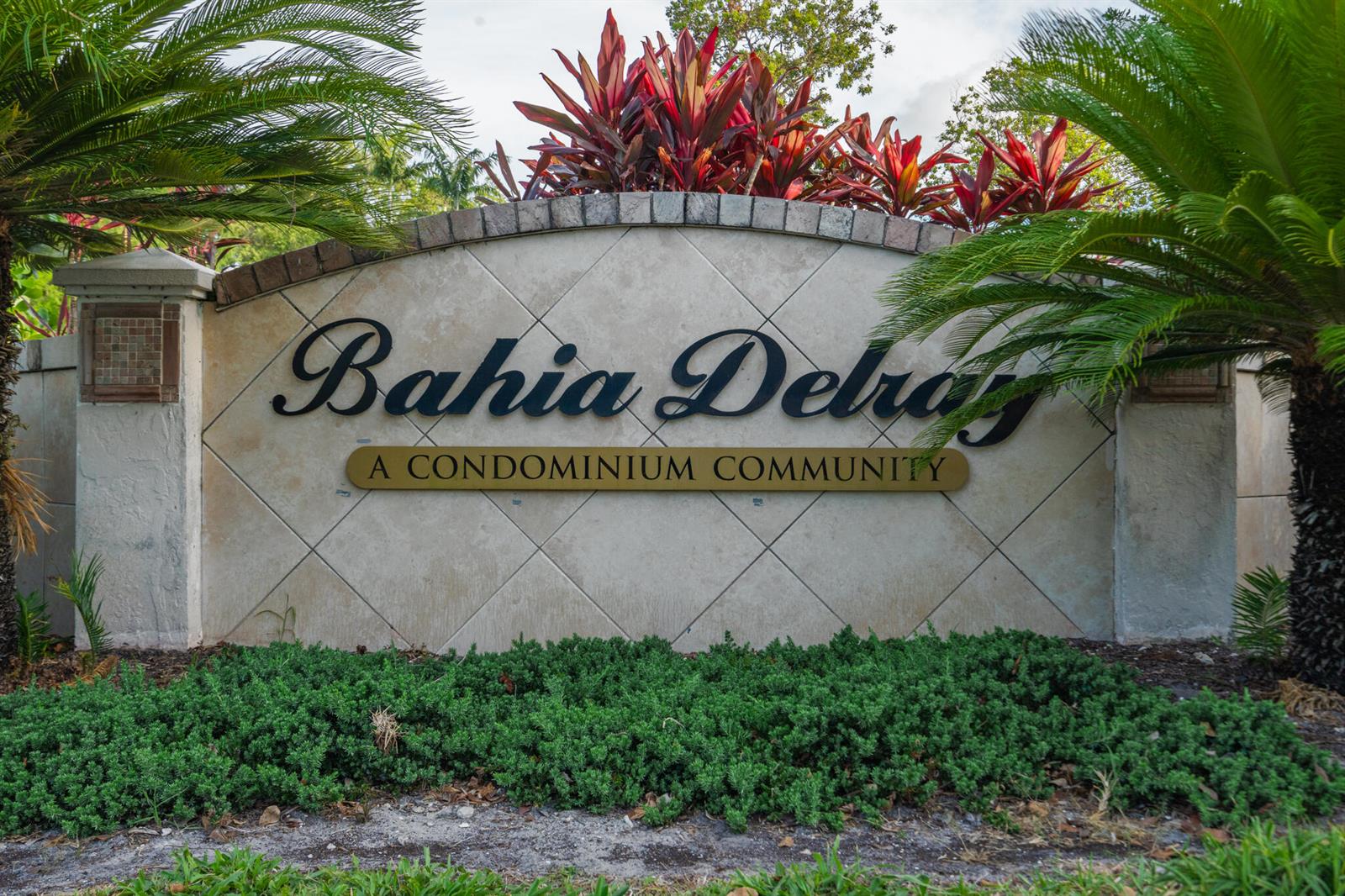 A stone monument sign for Bahia Delray condominium community sits behind a low green hedge — 1000 Crystal Way # L, FL 33444, FL