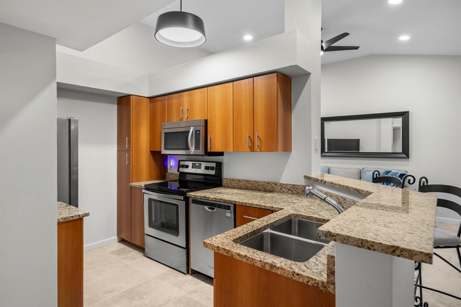 A kitchen features wood cabinets, granite countertops, stainless steel appliances, and a double sink — 1000 Crystal Way # L, FL 33444, FL