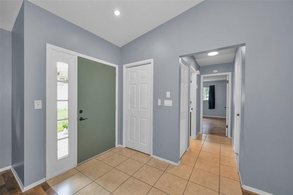 An entryway features a green front door, tile flooring, and a hallway leading to rooms — 13005 CLUB DRIVE, HUDSON, FL
