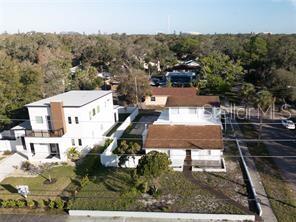 An aerial view shows two adjacent houses with white and brown exteriors and surrounding landscaping — 1301 26TH AVENUE S, ST PETERSBURG, FL