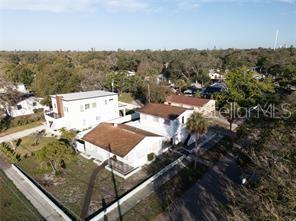 An aerial view shows a white house with a brown roof and a neighboring structure — 1301 26TH AVENUE S, ST PETERSBURG, FL