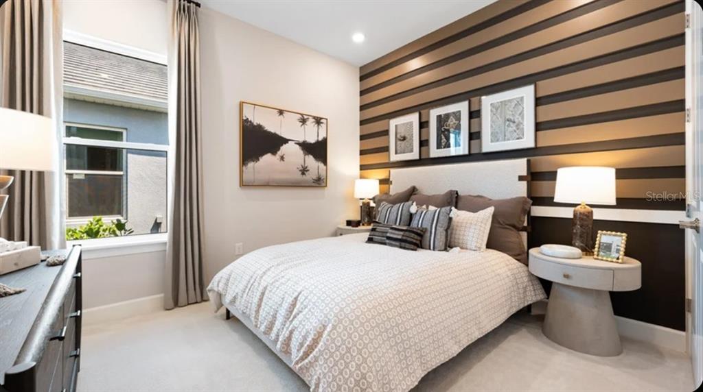 A bedroom features a bed against a wall with horizontal brown and black wood slats — 17742 SEDONA STREET, WINTER GARDEN, FL