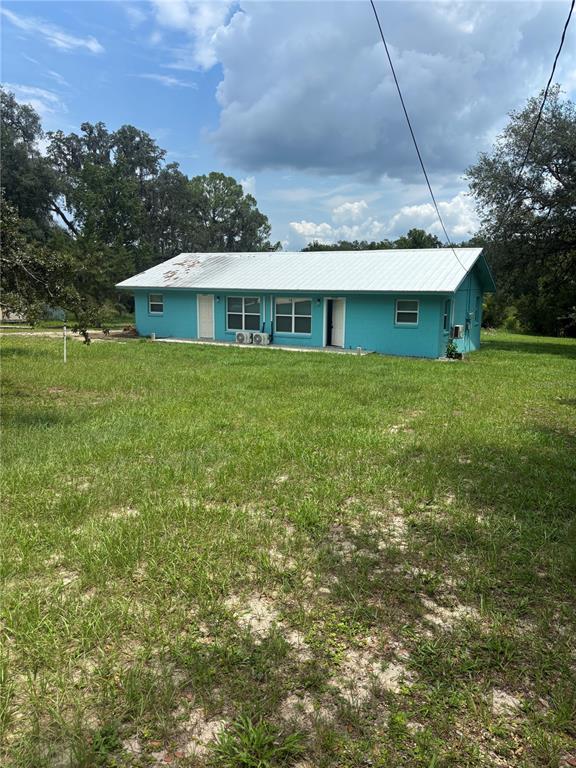 A single-story turquoise house with a metal roof sits on a grassy lot — 4035 N HIGHWAY 314A UNIT 2, SILVER SPRINGS, FL