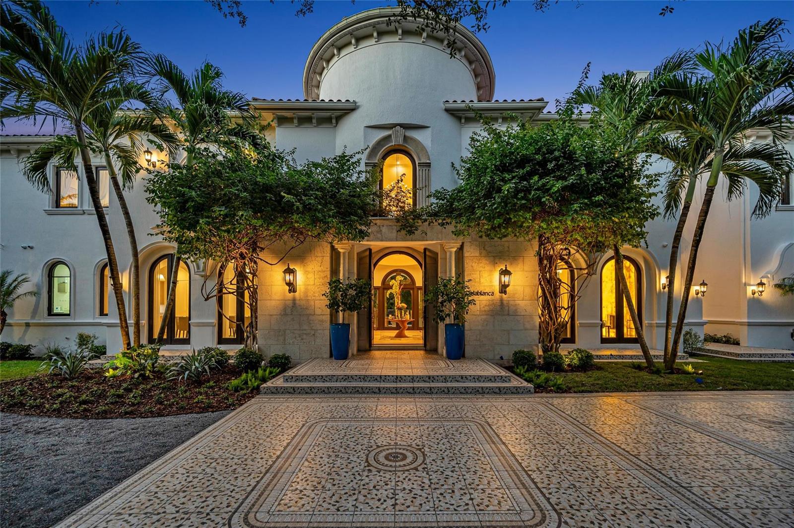 The exterior of a white Mediterranean-style mansion features a tiled courtyard and arched entryways — 4955 SW 83rd Street, Miami FL 33143, MIAMI, FL
