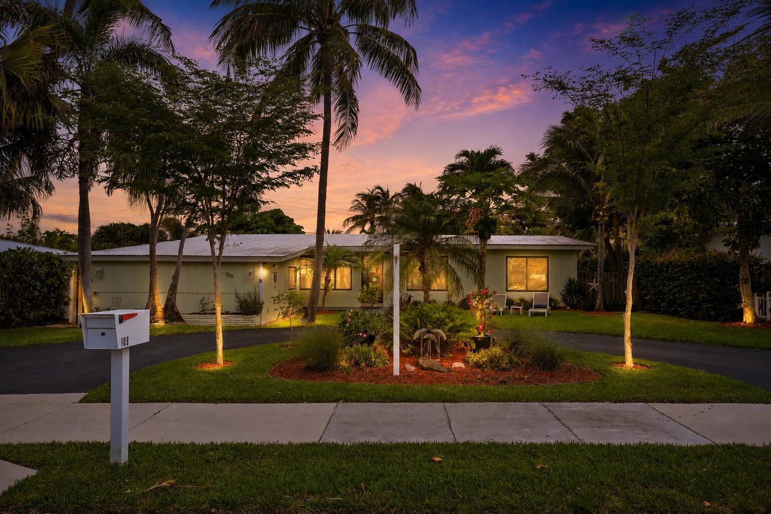 A single-story house with a circular driveway and palm trees at sunset — 109 NE 17th Street, Delray Beach FL 33444, DELRAY BEACH, FL