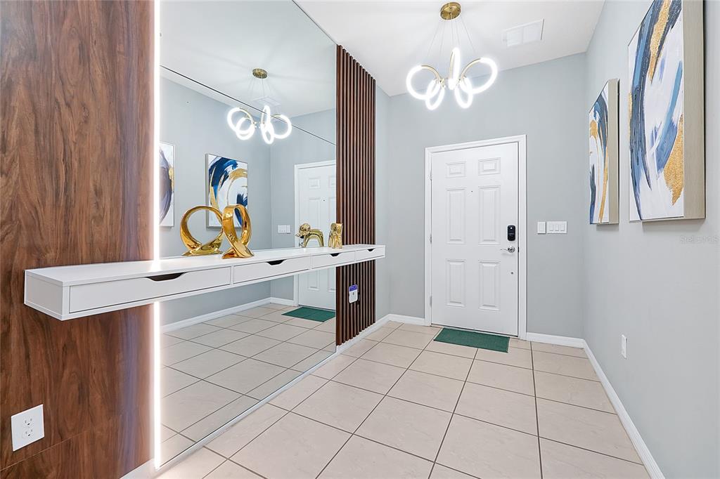 An entryway features a floating white console, a large mirror, and vertical wood slat accents — 4494 KAIPO ROAD, DAVENPORT, FL