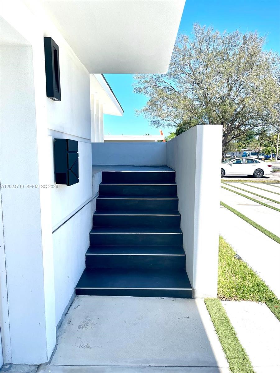A set of dark stairs leads up to a modern white building entrance — 19960 Highland Lakes Blvd, Miami FL 33179, MIAMI, FL