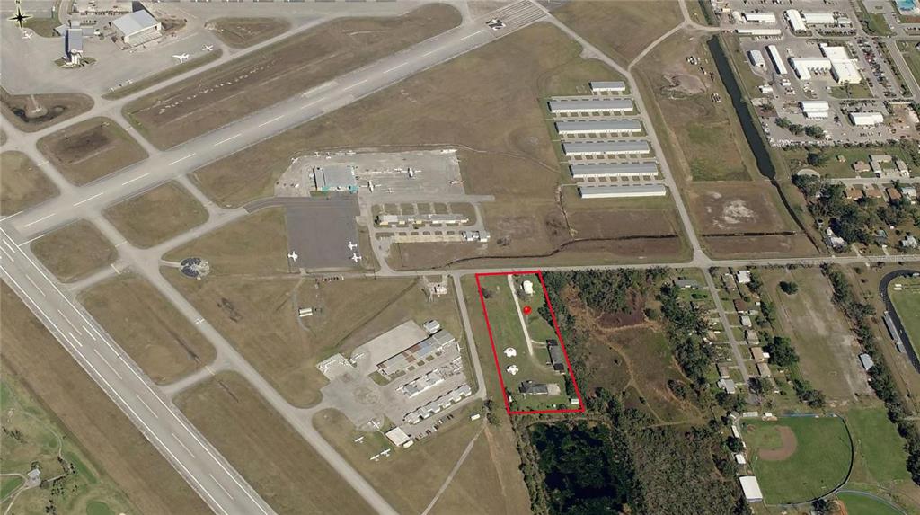 An aerial view shows a rectangular property lot outlined in red adjacent to an airport runway — 2804 PATRICK STREET, KISSIMMEE, FL