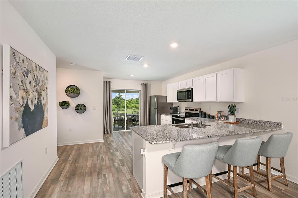 A single-story house with a beige stucco exterior, a two-car garage, and a blue door — 3217 WARWICK PLACE, HAINES CITY, FL