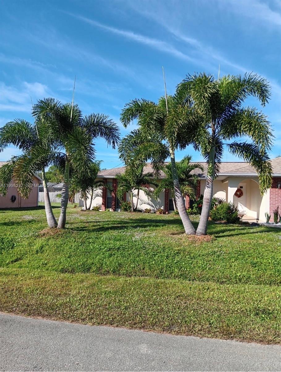 A single-story house with a brick facade and two large palm trees in the front yard — 146 BONFIRE, Palm Bay FL 32907, PALM BAY, FL