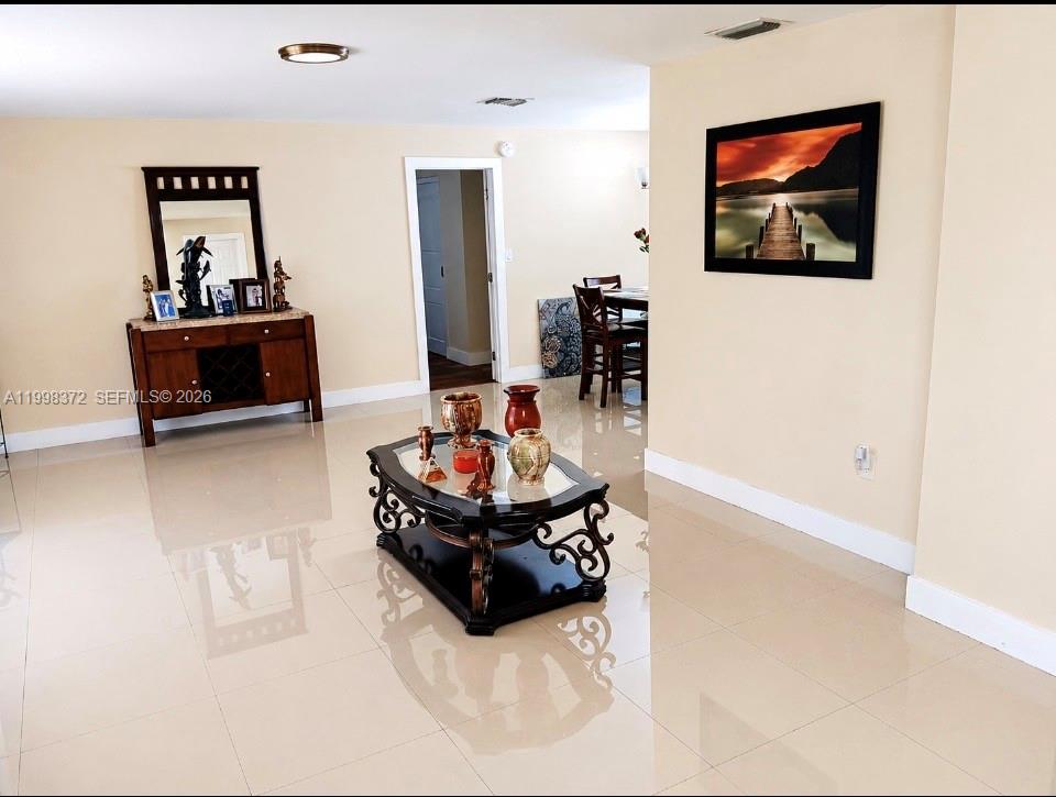 A living room features light-colored tile floors, a dark wood console table, and a coffee table — 146 BONFIRE, Palm Bay FL 32907, PALM BAY, FL