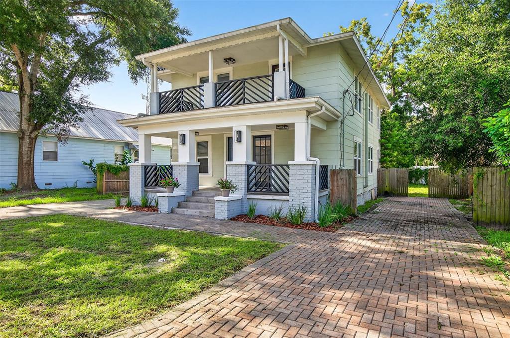 A two-story house with a front porch, a second-story balcony, and a brick paver driveway — 809 E BAKER STREET UNIT A, TAMPA, FL