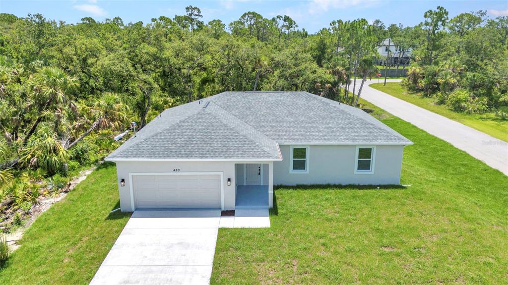 An aerial view of a single-story house with a gray roof and a concrete driveway — 420 HOFFER STREET, PORT CHARLOTTE, FL