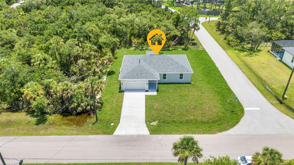 An aerial view shows a single-story house with a gray roof, garage, and concrete driveway — 420 HOFFER STREET, PORT CHARLOTTE, FL