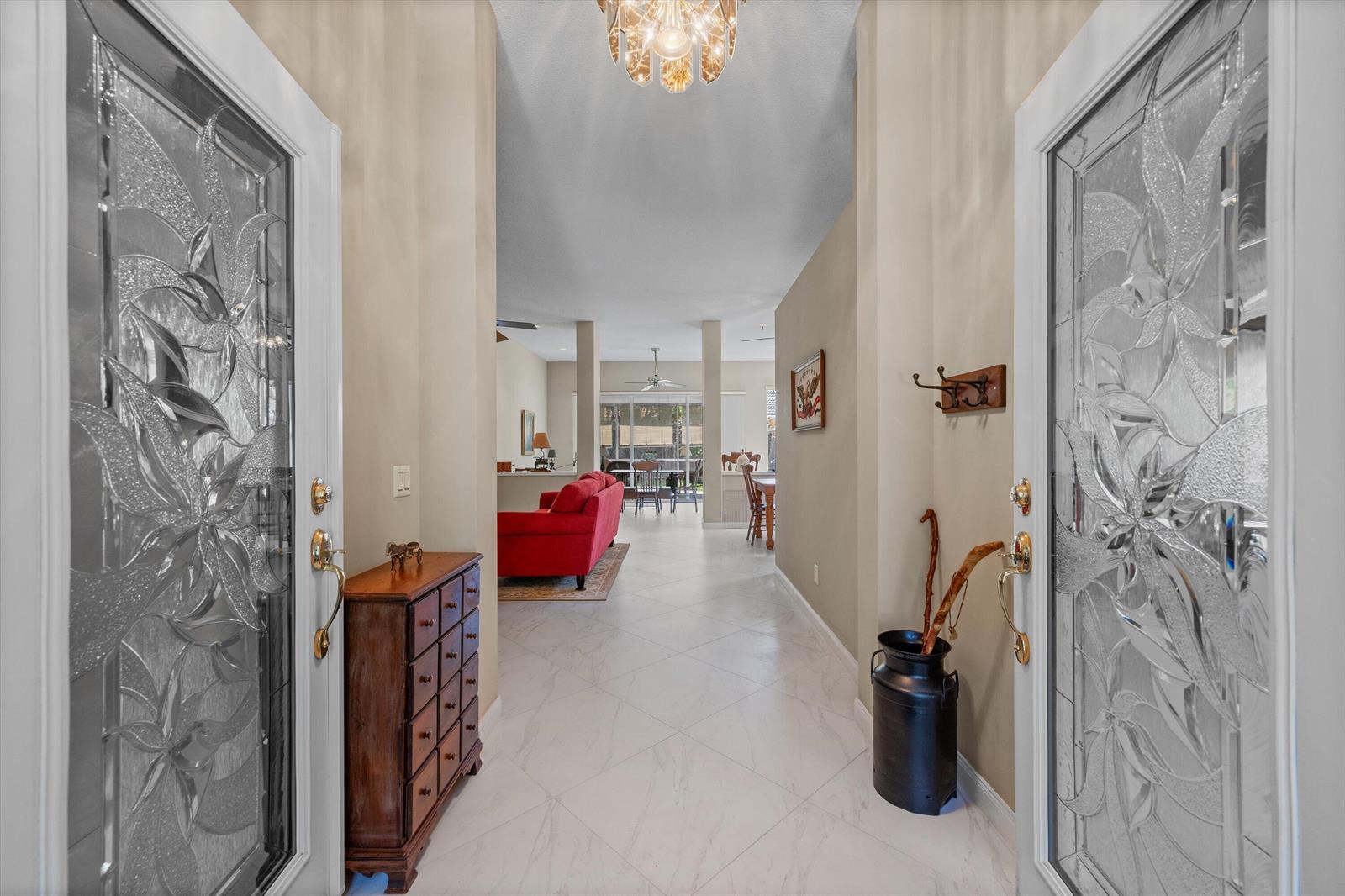 A bright entryway features double glass-paneled doors, tiled floors, and a view into the home — 178 Hampton Place, Jupiter FL 33458, JUPITER, FL