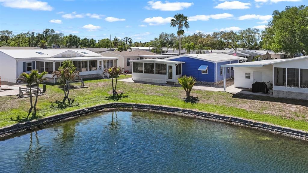 An aerial view shows several mobile homes situated along the edge of a small pond — 101 SAINT GEORGE COURT, APOLLO BEACH, FL