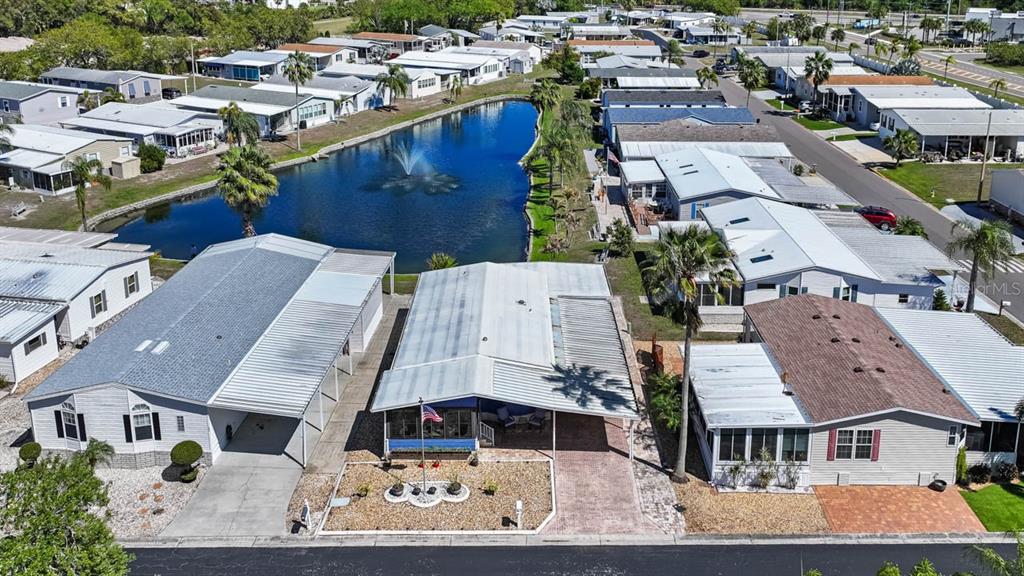 An aerial view shows a manufactured home community with a central pond and fountain — 101 SAINT GEORGE COURT, APOLLO BEACH, FL
