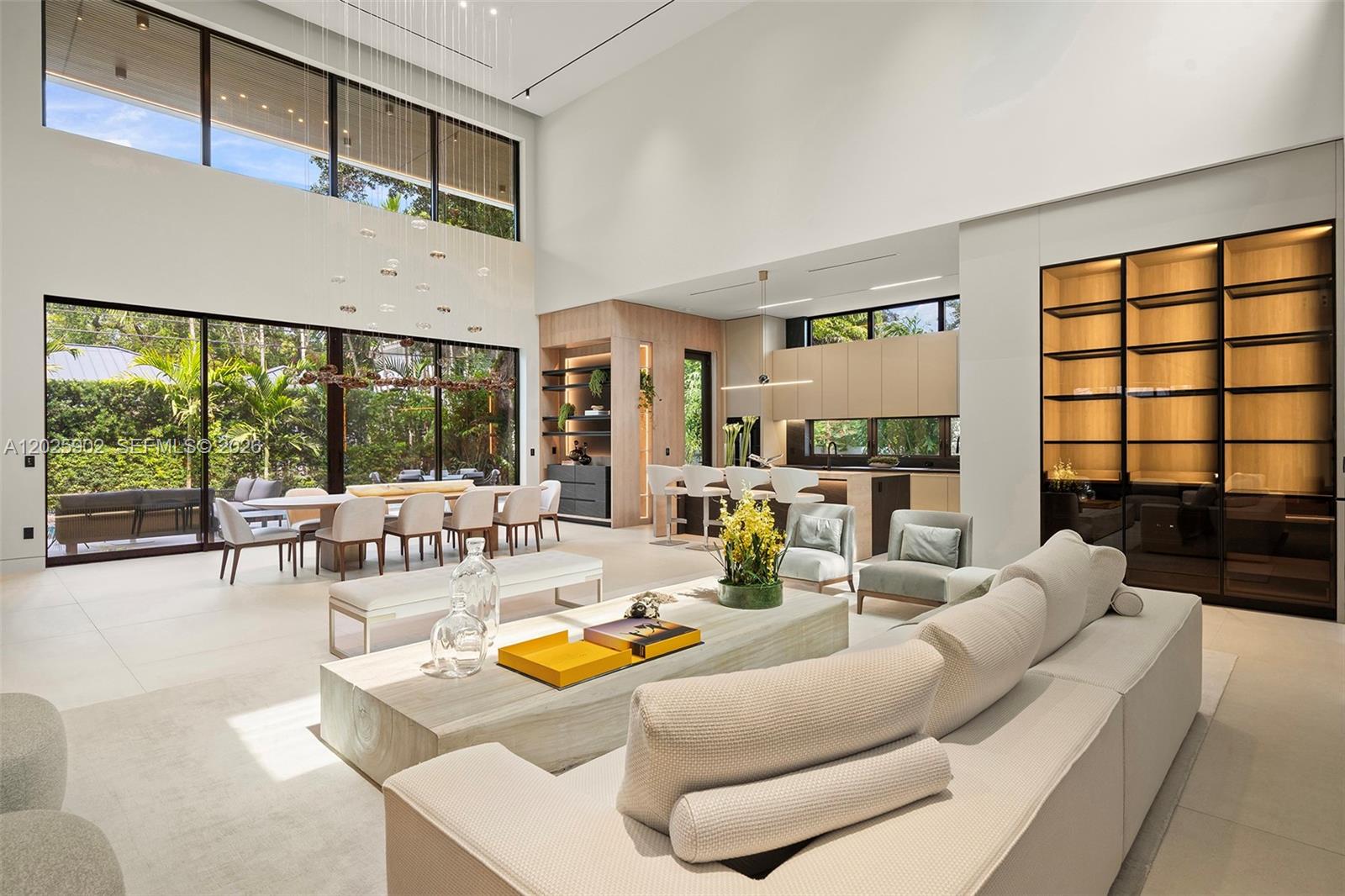 A spacious, high-ceilinged open-plan living and dining area features modern furniture and large glass walls — 7895 SW 52nd Ct, Miami FL 33143, MIAMI, FL