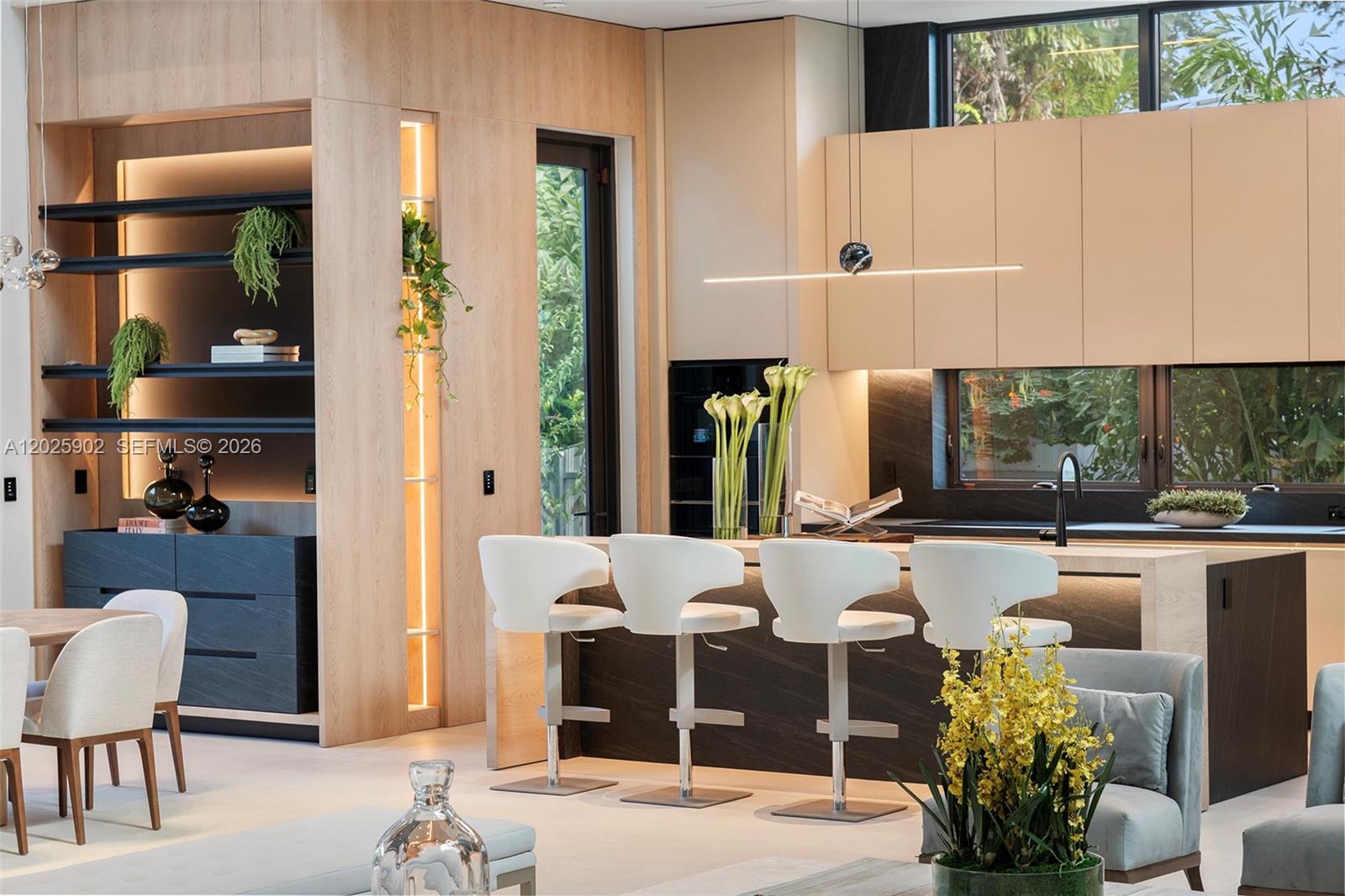 A modern kitchen features a central island with white bar stools and light wood cabinetry — 7895 SW 52nd Ct, Miami FL 33143, MIAMI, FL