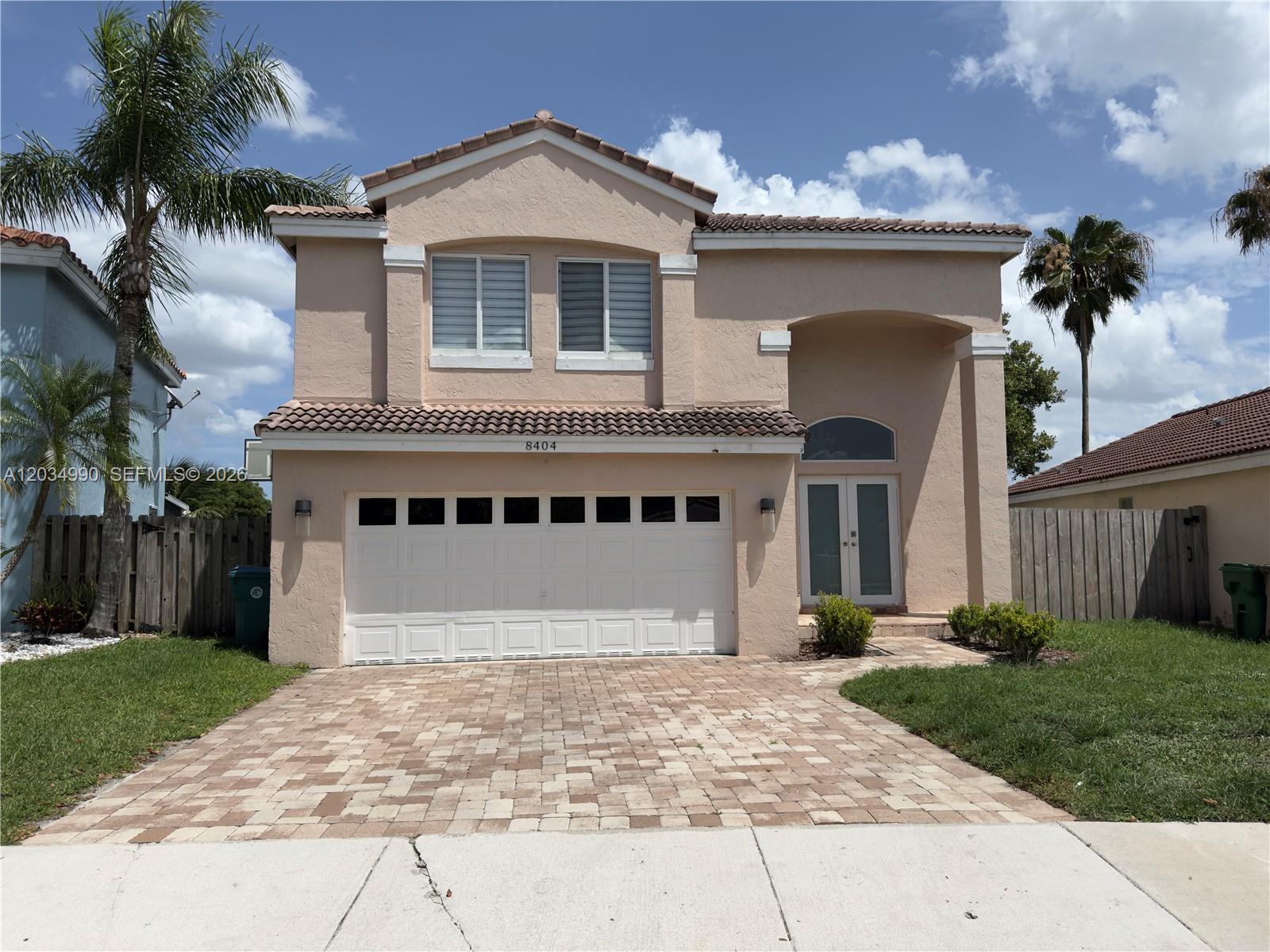 A two-story stucco house features a two-car garage, a paved driveway, and a tiled roof — 8404 SW 42nd Ct, Davie FL 33328, DAVIE, FL