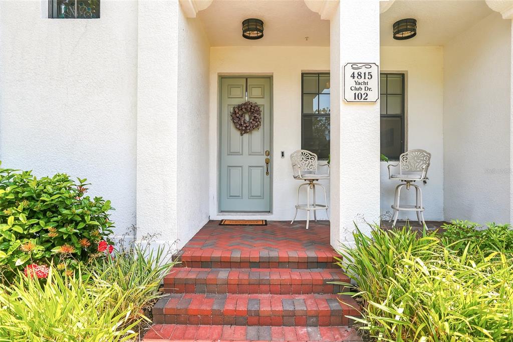 A living room features a light-colored sectional sofa, hardwood floors, and an adjacent dining area — 4815 YACHT CLUB DRIVE UNIT 102, TAMPA, FL