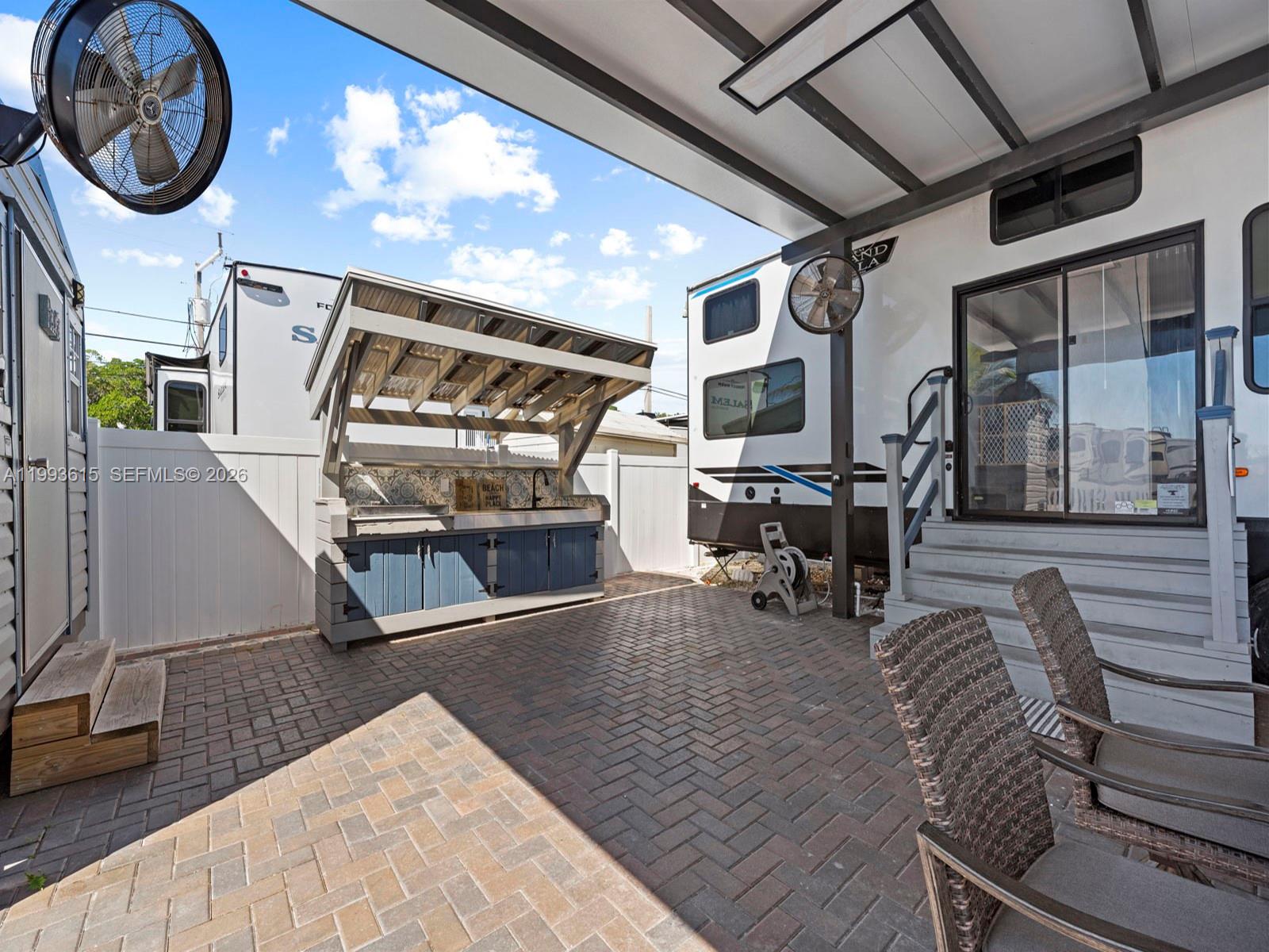 An outdoor patio features a brick floor, a kitchen island, and two recreational vehicles — 325 Calusa ST 321, Key Largo FL 33037, KEY LARGO, FL
