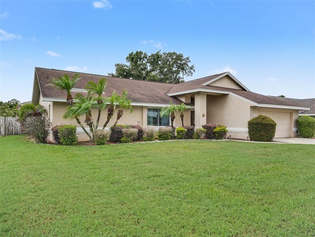 A living room features vaulted ceilings, hardwood floors, a sofa, armchairs, and a coffee table — 2810 WINTERSET PARK, WINTER HAVEN, FL