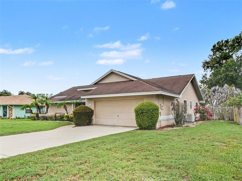 A living room features hardwood floors, vaulted ceilings, a glass coffee table, and built-in shelving — 2810 WINTERSET PARK, WINTER HAVEN, FL