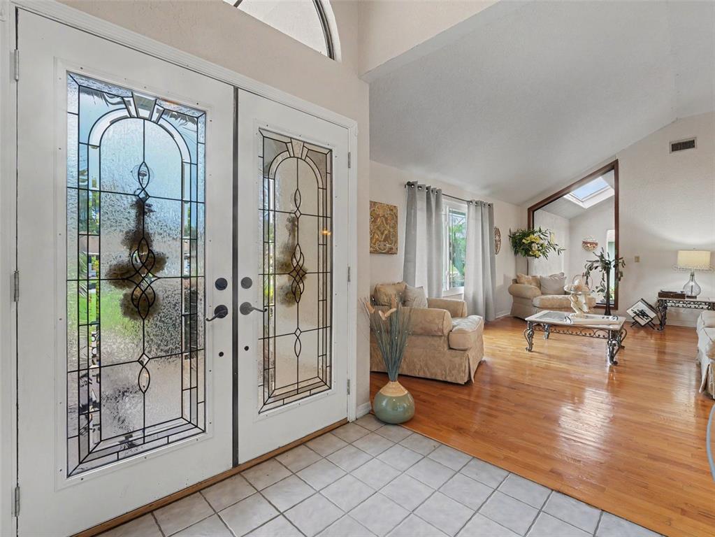 A dining room features a wooden table, upholstered chairs, a chandelier, and sliding glass doors — 2810 WINTERSET PARK, WINTER HAVEN, FL