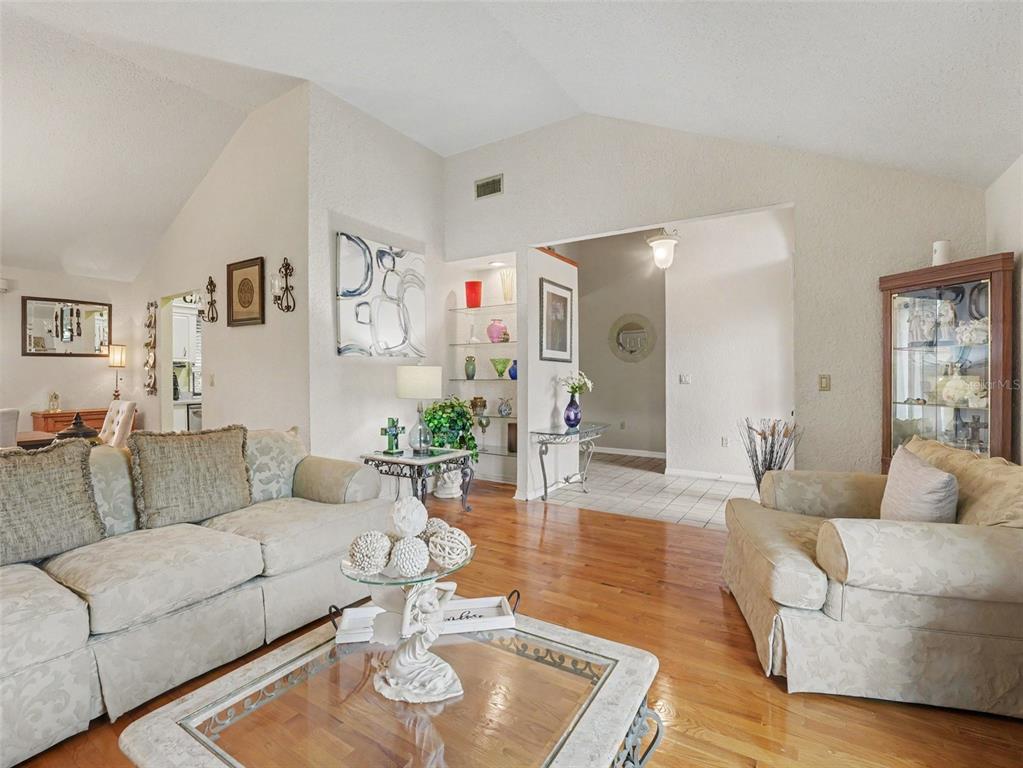 A living room features a white brick fireplace, a wooden mantel, and a brown recliner — 2810 WINTERSET PARK, WINTER HAVEN, FL