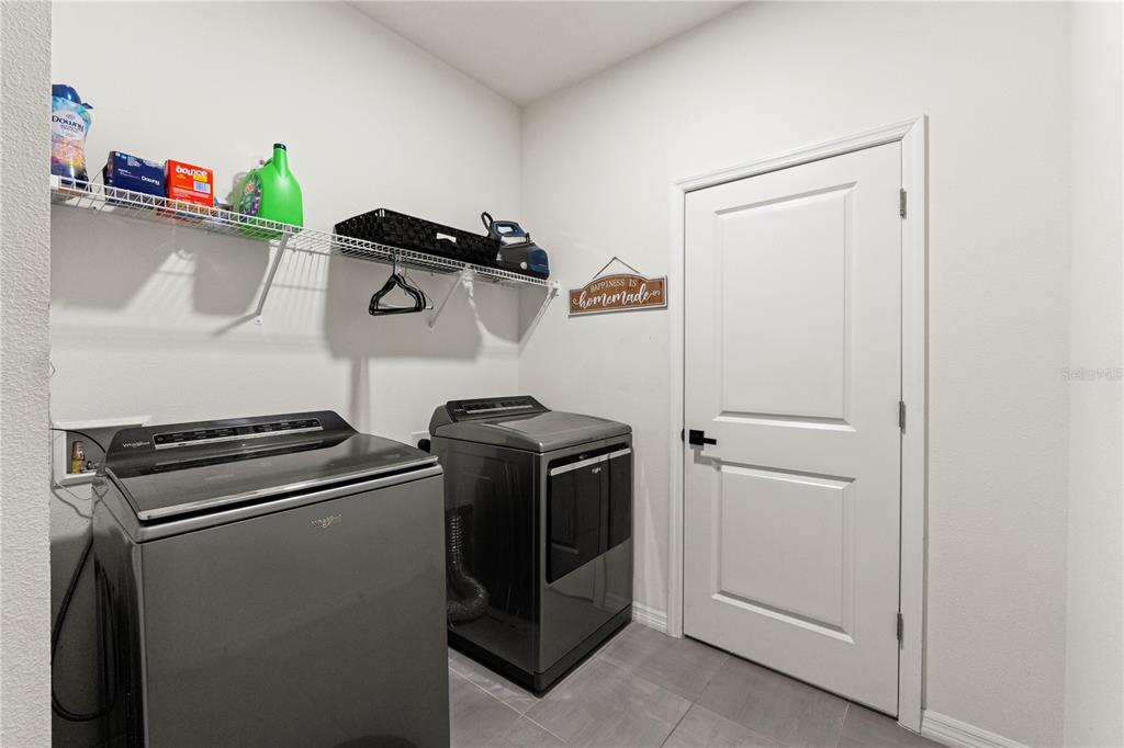 A view from an open front door into a tiled entryway leading to a living area — 3763 AUTUMN AMBER DRIVE, SPRING HILL, FL